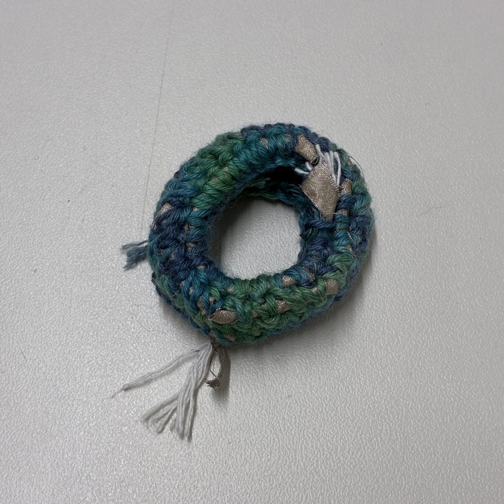With a spiral structure. The cloth was bound onto the surface of a strip. Then, a method for creating a circular mat was applied.